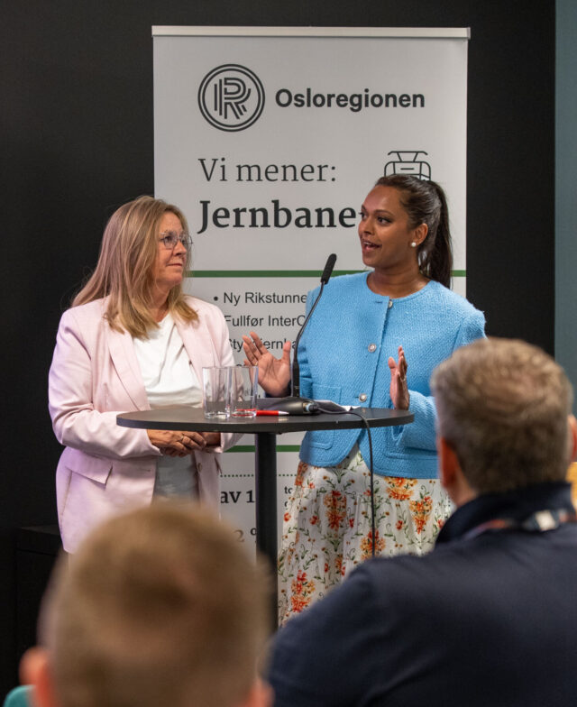 To kvinner som snakker foran publikum