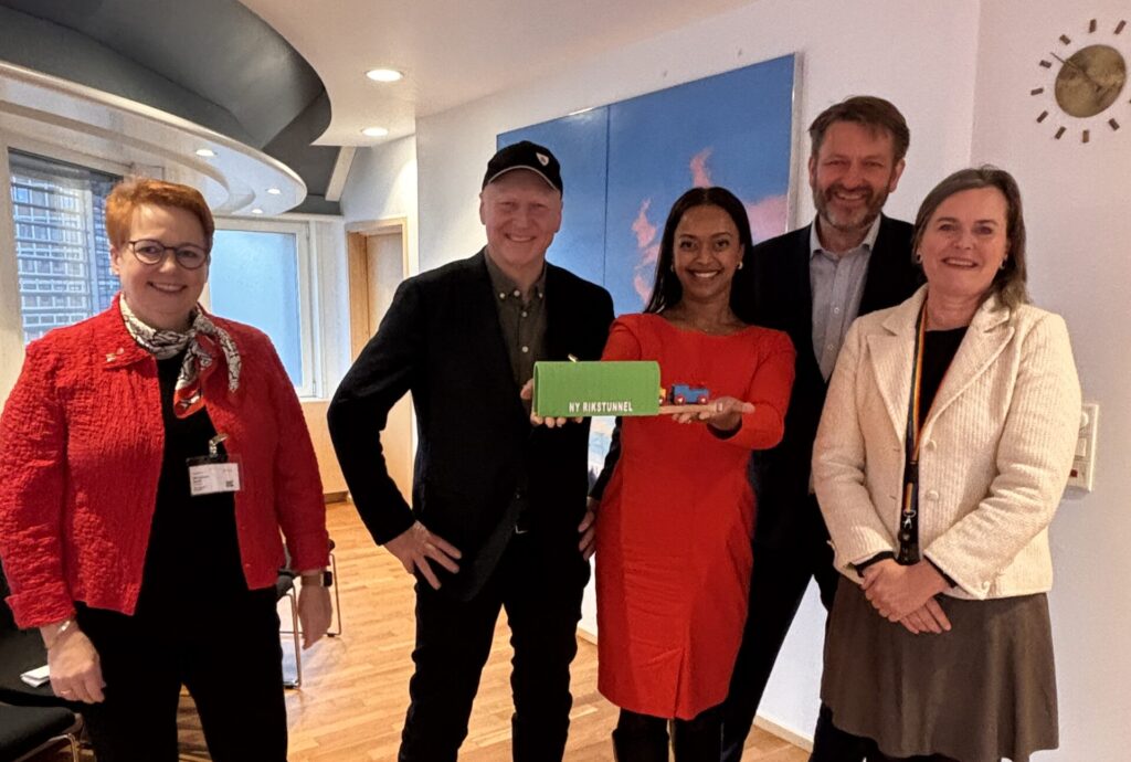 fem personer ser i kamera og smiler