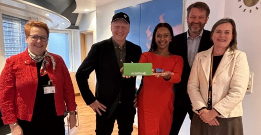 fem personer ser i kamera og smiler