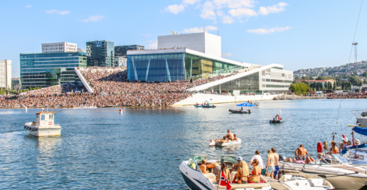 Operaen i Oslo med mange mennesker. Blått hav og blå himmel